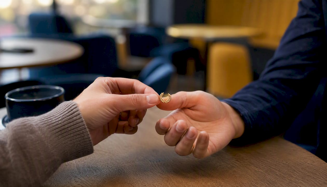 Hand giving laurel wreath pin recognition