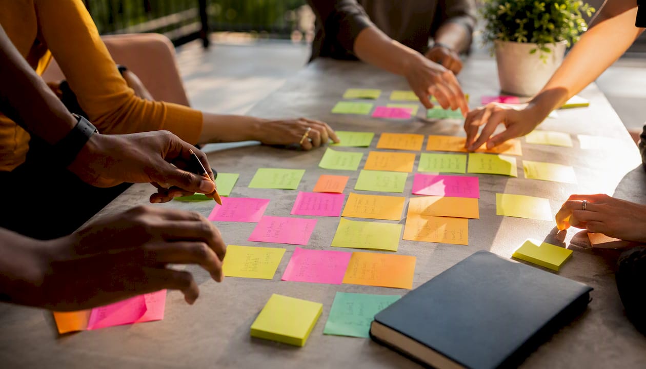 Hands organizing sticky notes for brain dump
