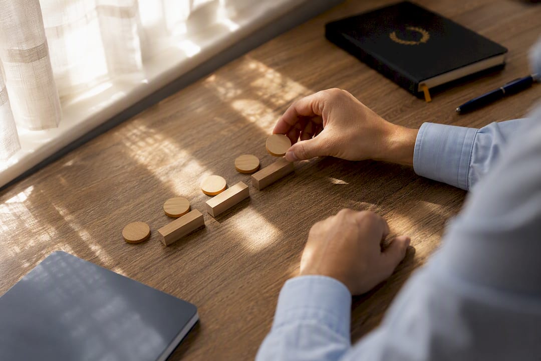 Hands arranging milestone tokens on desk