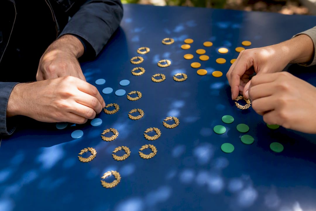 Hands assigning project role tokens on table