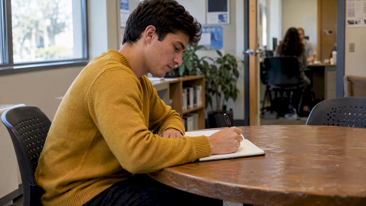 Young professional writing a work goal